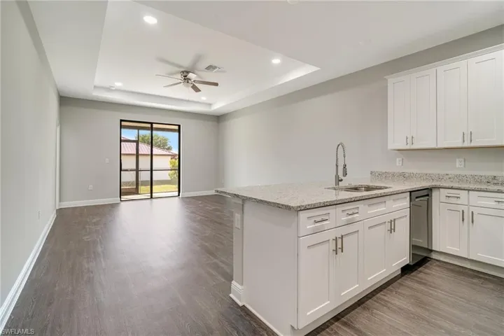 Kitchen featuring white cabinetry, ceiling fan, light stone countertops, recessed lighting, and dark wood-style floors
