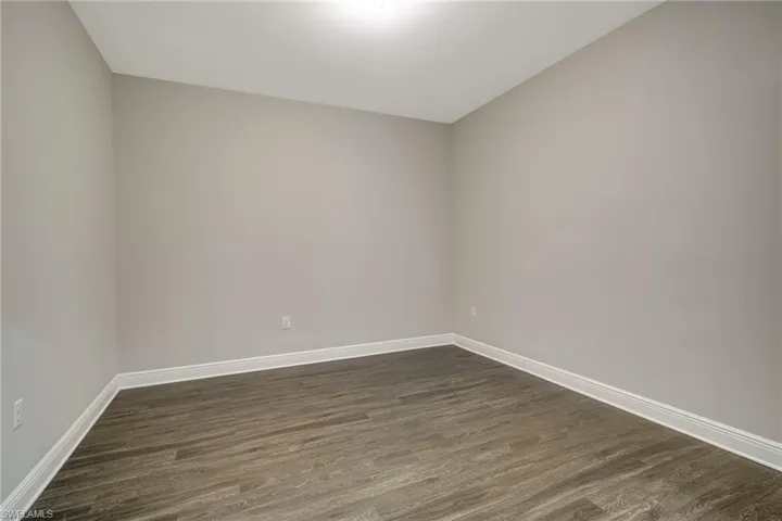 Spare room with dark wood finished floors and baseboards