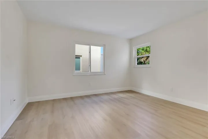 Unfurnished room featuring light wood finished floors and baseboards