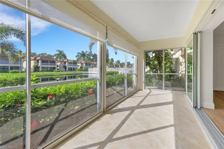 Unfurnished sunroom featuring tile patterned flooring and a water view
