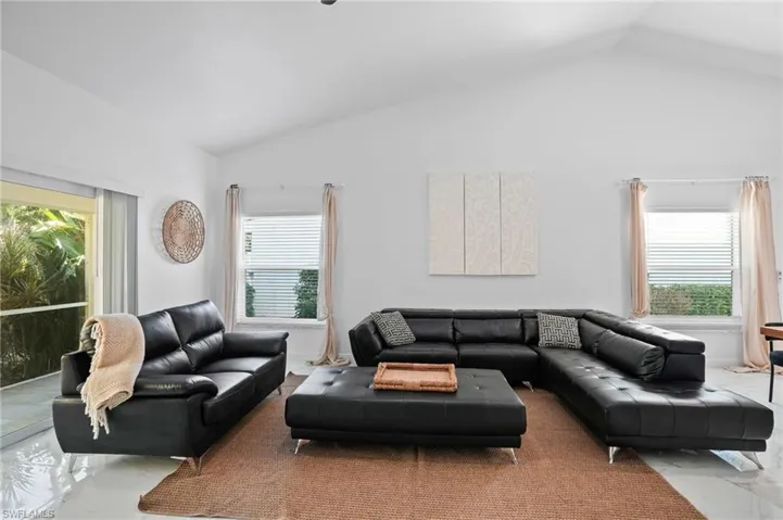 Living area with marble tiled flooring and vaulted ceiling