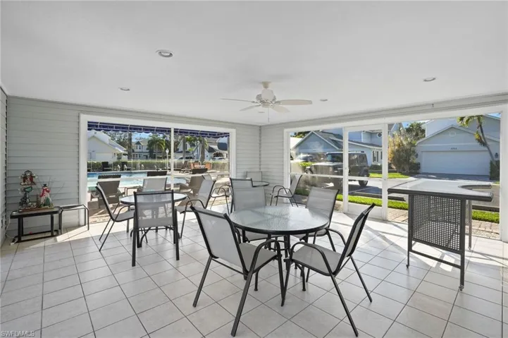 Sunroom with tile patterned floors and wooden walls