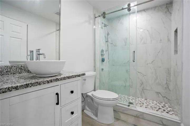 Full bath with vanity and a marble finish shower