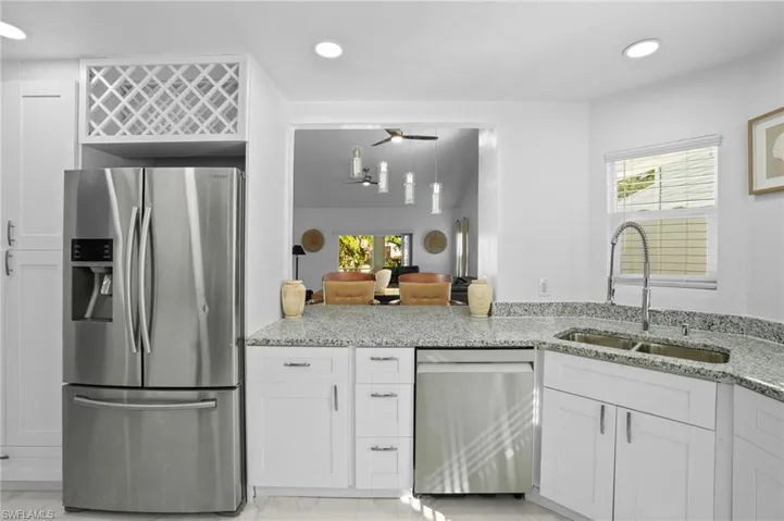 Kitchen with stainless steel appliances, light stone countertops, white cabinetry, and recessed lighting