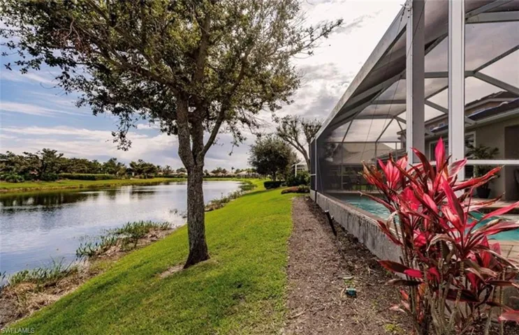 View of yard with glass enclosure and a water view