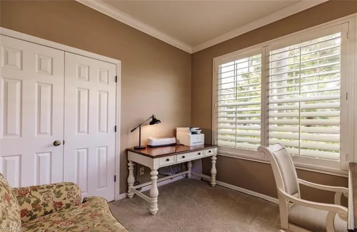 Carpeted office featuring a wealth of natural light and ornamental molding