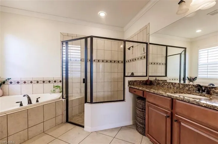 Bathroom with crown molding, vanity, tile patterned floors, and shower with separate bathtub