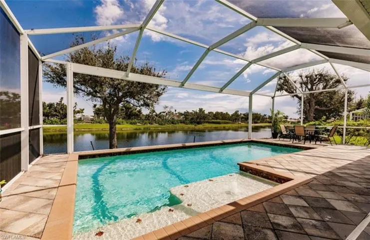 View of swimming pool featuring a lanai, a patio, and a water view