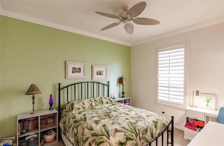 Bedroom with carpet flooring, ceiling fan, and ornamental molding