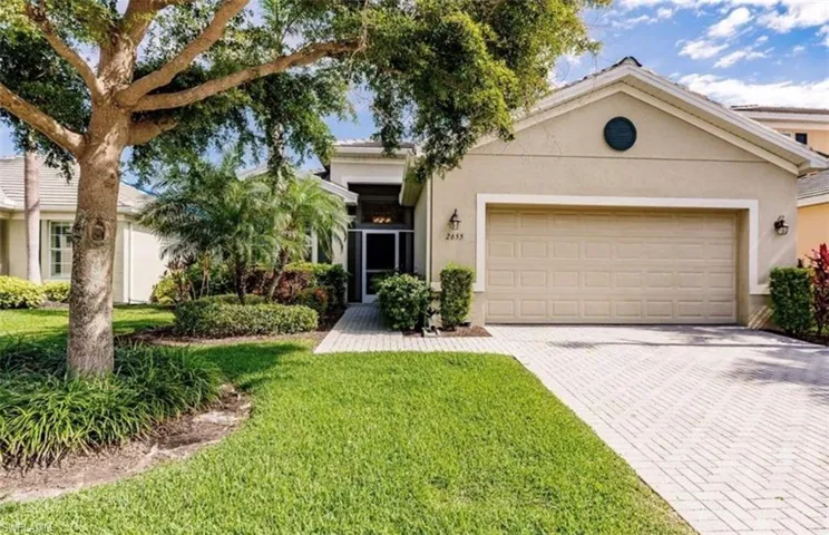 Ranch-style home featuring a garage and a front lawn