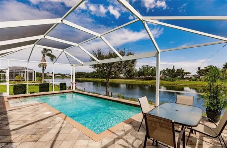 View of pool with a lanai, a water view, and a patio