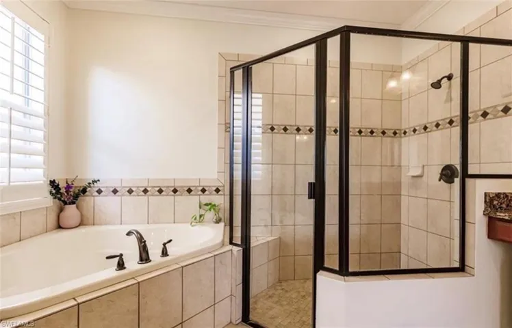 Bathroom with ornamental molding, plenty of natural light, and separate shower and tub