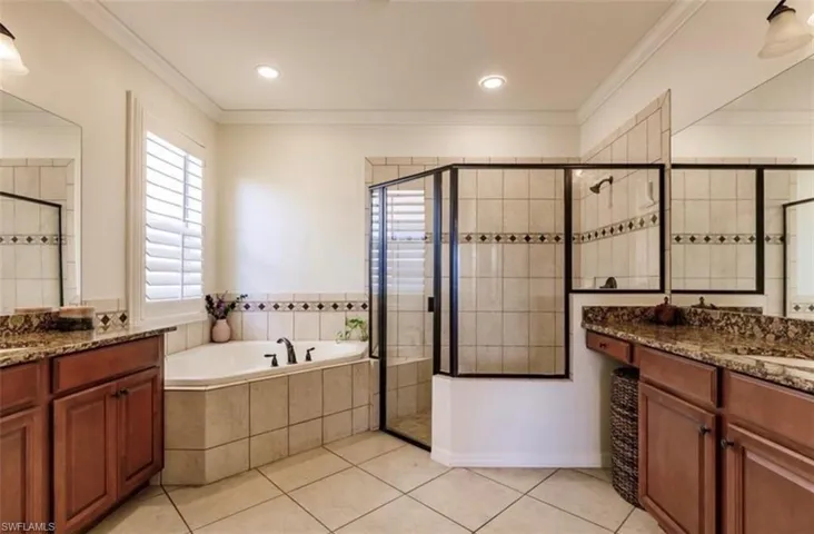 Bathroom with crown molding, vanity, and shower with separate bathtub