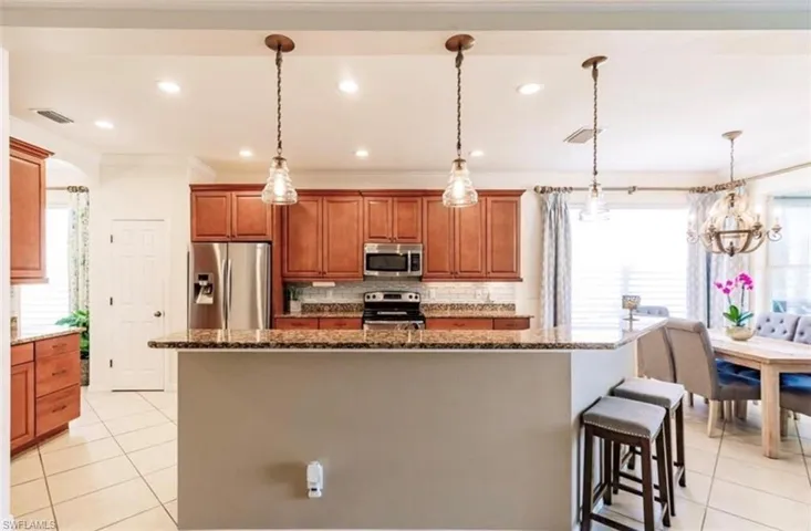 Kitchen featuring appliances with stainless steel finishes, a wealth of natural light, and pendant lighting