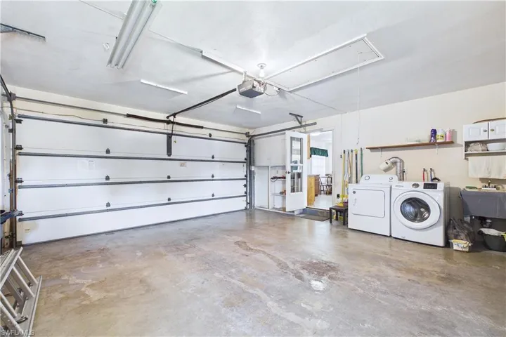 Garage featuring washer and clothes dryer and a garage door opener