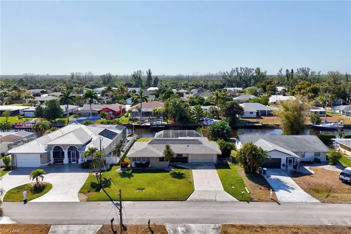 Aerial perspective of suburban area featuring a nearby body of water