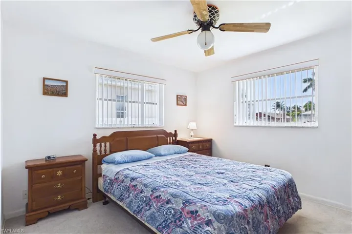 Carpeted bedroom featuring a ceiling fan and baseboards