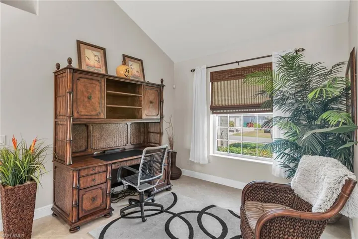 Office with baseboards, vaulted ceiling, and light tile patterned floors