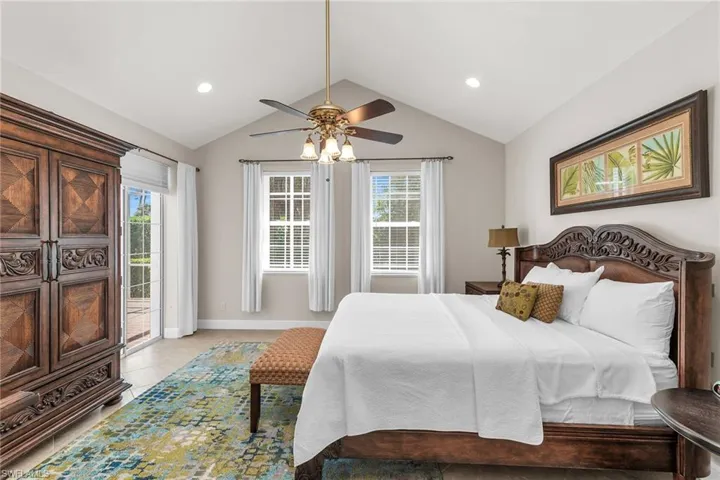 Bedroom with baseboards, access to outside, recessed lighting, vaulted ceiling, and light tile patterned floors