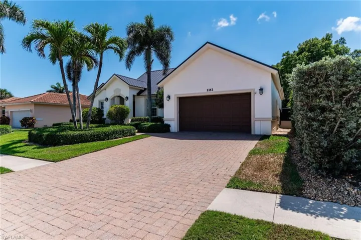 View of front of property with stucco siding, an attached garage, metal roof, and decorative driveway