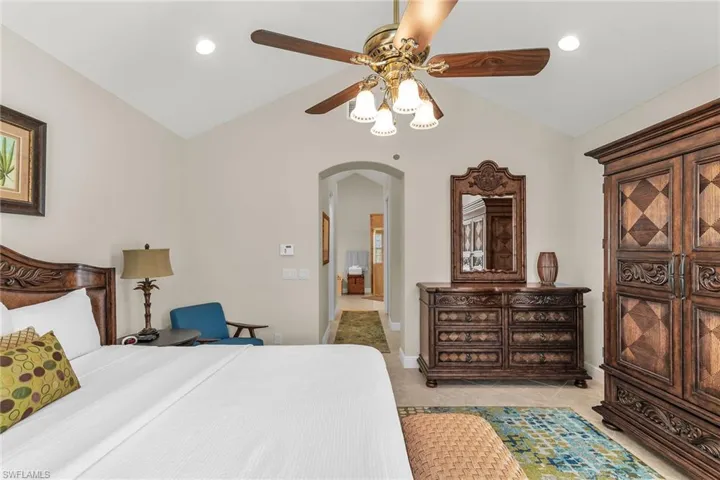 Bedroom with vaulted ceiling, arched walkways, recessed lighting, and a ceiling fan