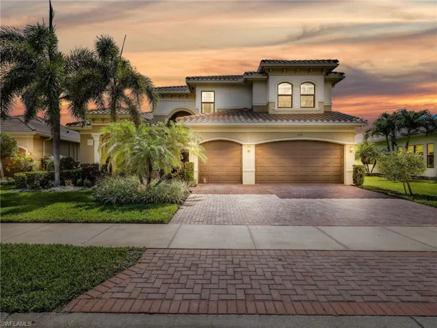 Mediterranean-inspired residence featuring a two-car garage with wood-finish doors