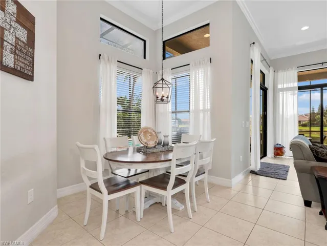 Dining area featuring high ceilings, transom windows, ceramic tile flooring, and direct access to an enclosed patio
