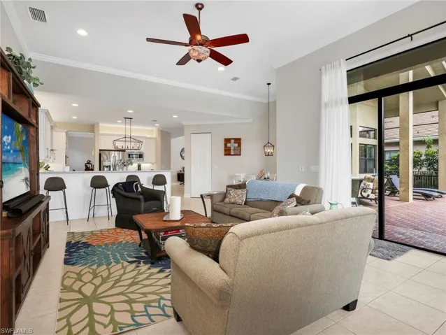 Open-concept living area with tile flooring and crown molding