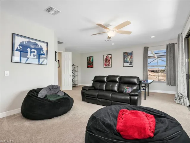 Spacious bonus room featuring neutral carpeting, a ceiling fan with integrated lighting, and recessed lighting