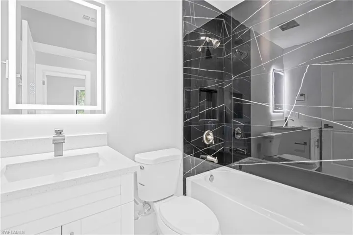 Full bath featuring vanity and washtub / shower combination