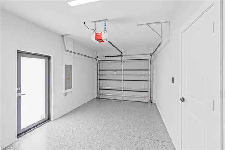 Garage featuring electric panel and a garage door opener