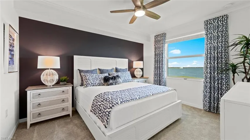 Bedroom featuring carpet floors, ornamental molding, a water view, and a ceiling fan