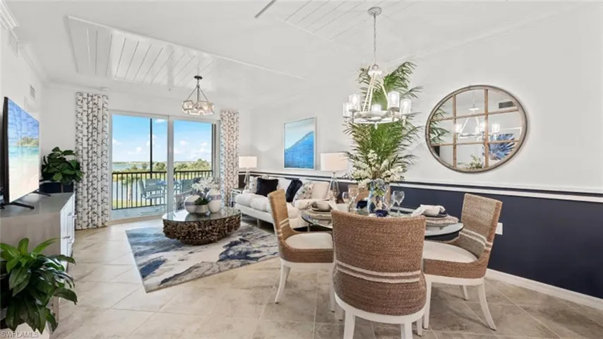 Tiled dining area featuring a chandelier, ornamental molding, and a water view