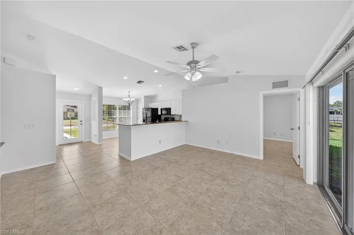 Spacious interior featuring tile flooring, vaulted ceilings, and a ceiling fan