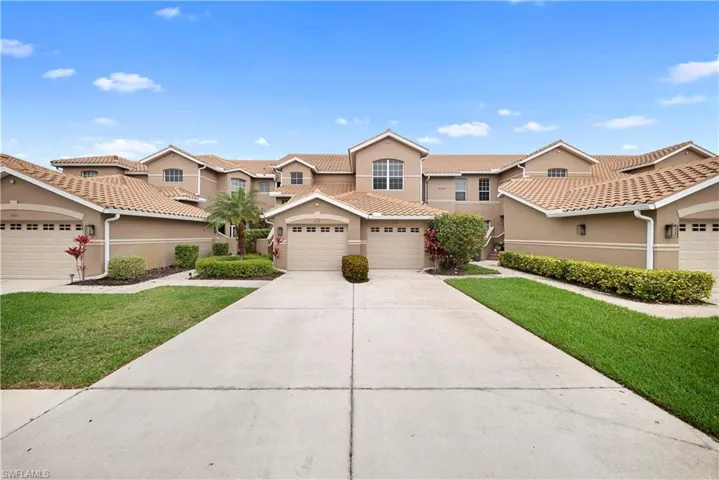 View of front of house featuring stucco siding, concrete driveway, a front lawn, and a garage