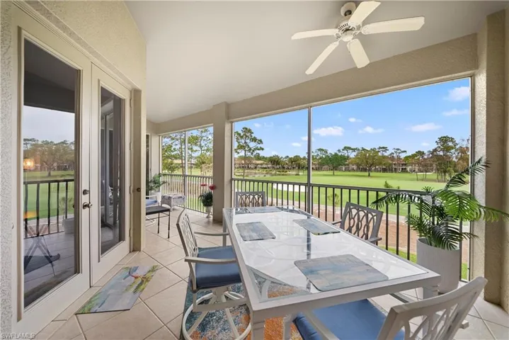 Oversized lanai golf course view, tile patterned flooring, french doors, and a textured wall