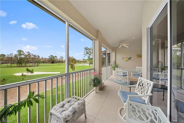 Sunroom / solarium with ceiling fan, golf course view, a balcony, outdoor dining space, and lofted ceiling