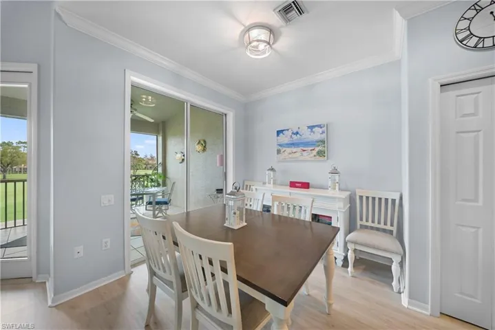 Dining space featuring crown molding and light wood-style flooring