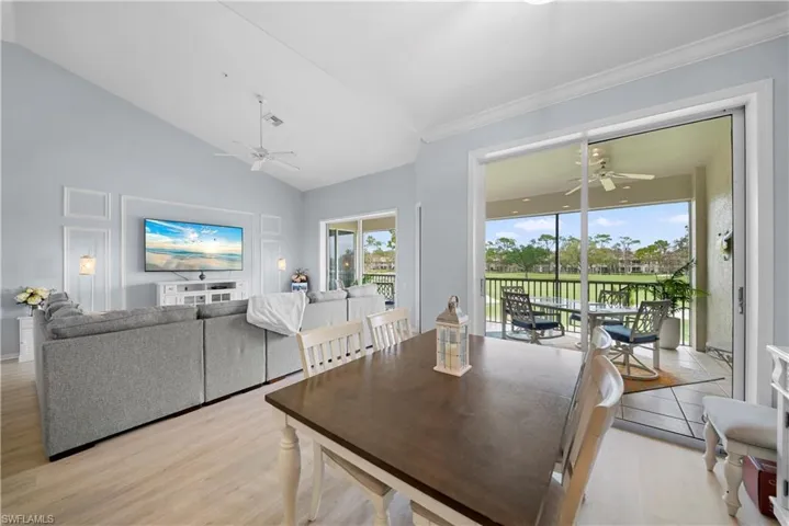 Dining space featuring a ceiling fan, light wood finished floors, and vaulted ceiling