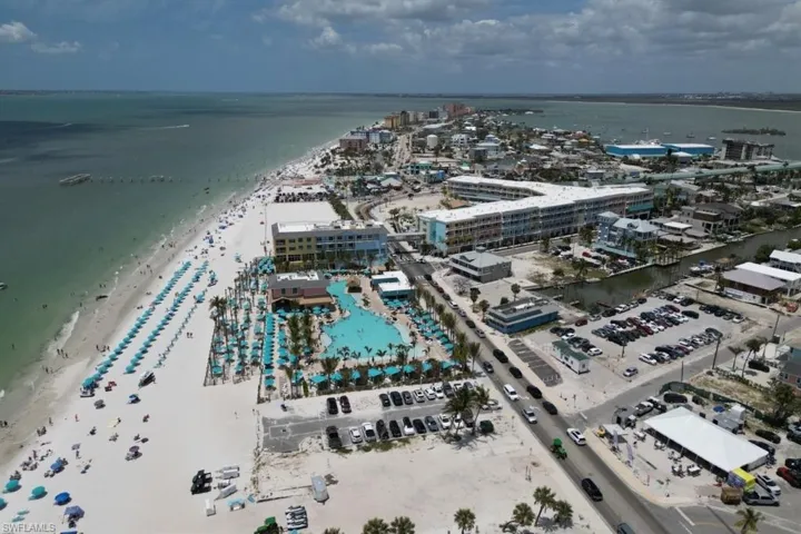 Aerial view of property and surrounding area with expansive coastline and nearby urban area
