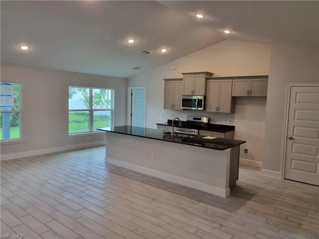 Kitchen featuring stainless steel appliances, a kitchen island with sink, sink, light hardwood / wood-style floors, and gray cabinetry