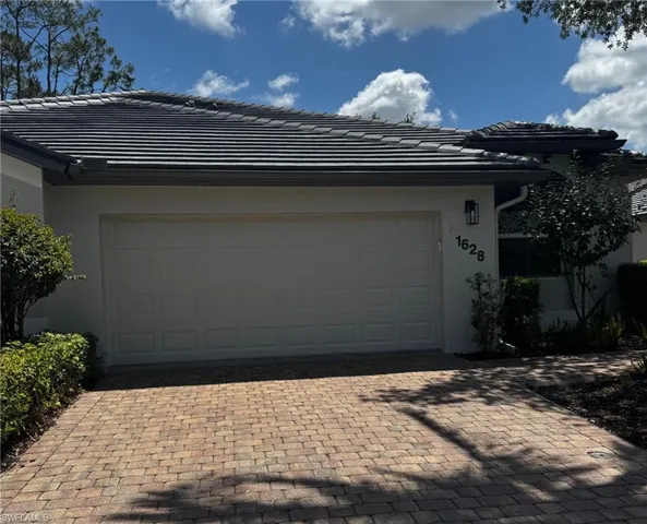 Garage featuring decorative driveway