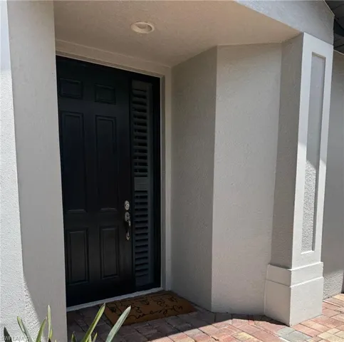Doorway to property with stucco siding