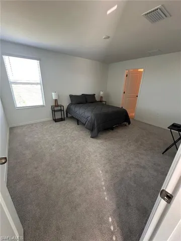 Bedroom featuring carpet flooring and lofted ceiling