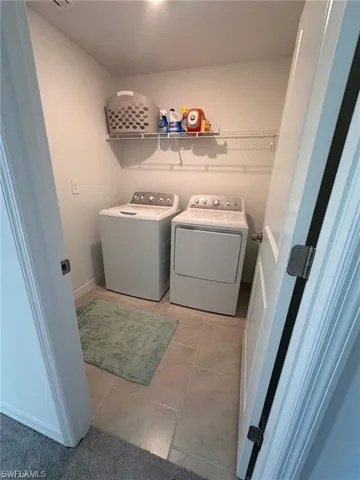 Laundry room featuring separate washer and dryer and light tile patterned flooring