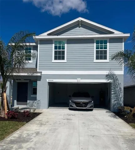 Traditional-style house featuring concrete driveway and a garage