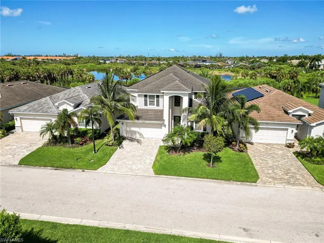View of front of house with a garage, a front lawn, and solar panels