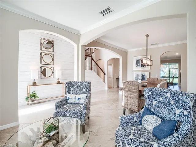 Living room featuring crown molding and light tile patterned floors