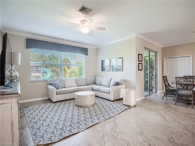 Tiled living room with crown molding and ceiling fan