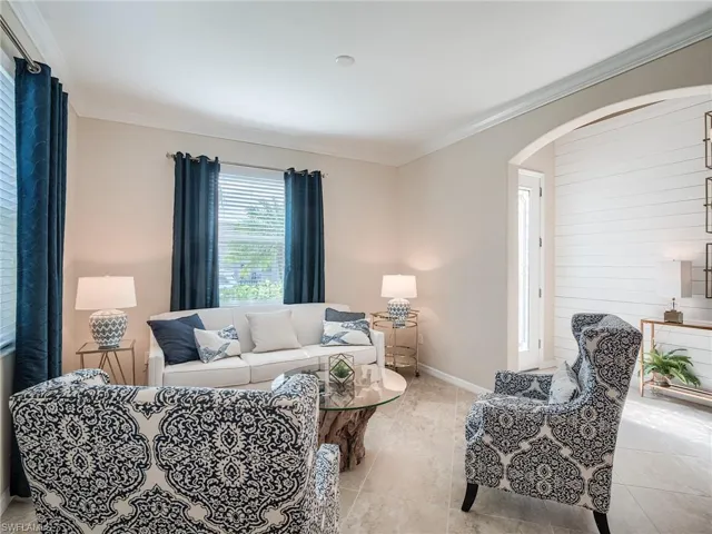 Living room featuring crown molding and light tile patterned floors